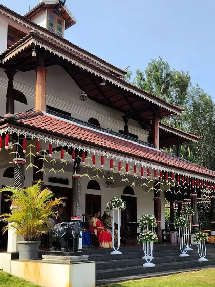 We specialize in transforming heritage homes for weddings. Here, we adorned the facade with traditional hangings made of coconut leaves and red flowers, complementing the home's architecture while adding a festive touch.