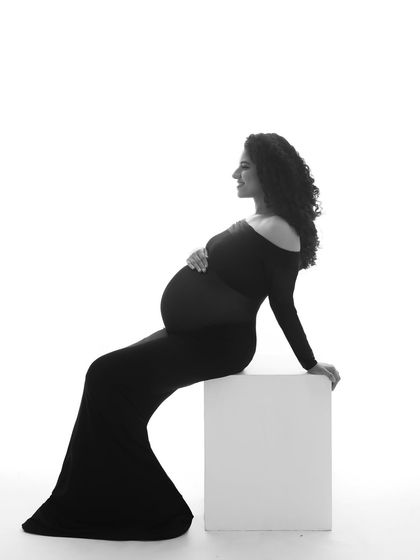 A stunning silhouette. This minimalist black and white portrait focuses on the beautiful shape of the mother's body, creating a powerful and artistic image.