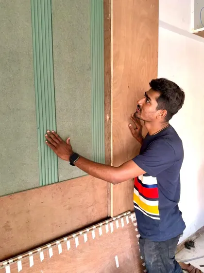 Admiring the newly installed fluted panels next to the raw plywood structure.