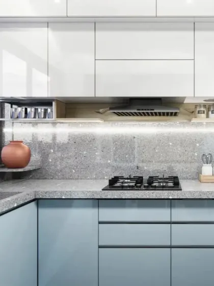 A modular kitchen with light blue cabinets and a terrazzo-style countertop. The under-cabinet lighting ensures a well-lit workspace.