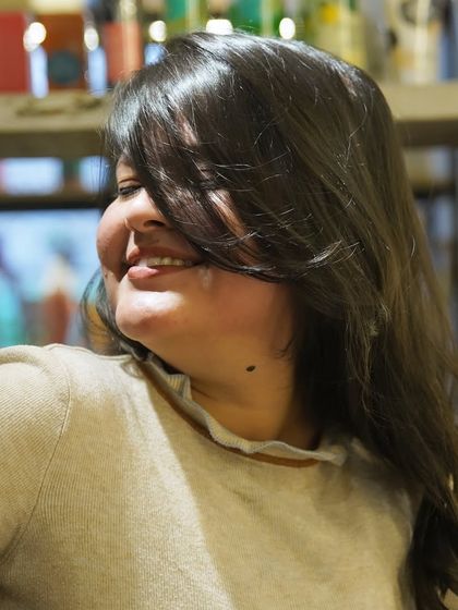 The smile that says it all. This happy client is enjoying her fresh new style, a testament to the transformative power of a great haircut and a little pampering.