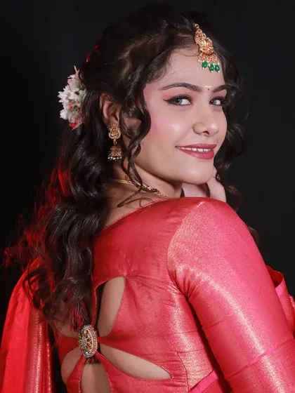A student's portfolio work featuring a South Indian bridal look with a pink saree and elegant hairstyle.