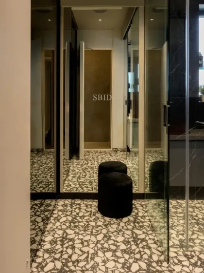 Terrazzo-style flooring and mirrored walls create a sense of space in this compact yet stylish bathroom.