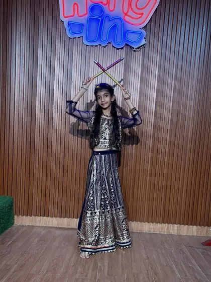 Dressed in an elegant navy blue and gold outfit, this dancer is ready for her performance. We pay attention to every detail, from choreography to costume.