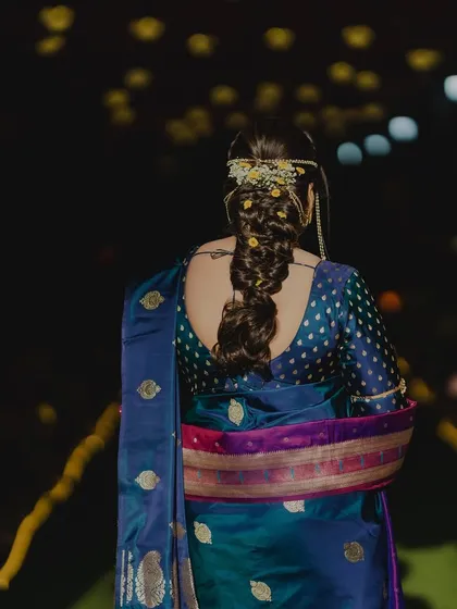 A view of the intricate braided hairstyle adorned with flowers, completing the traditional look.
