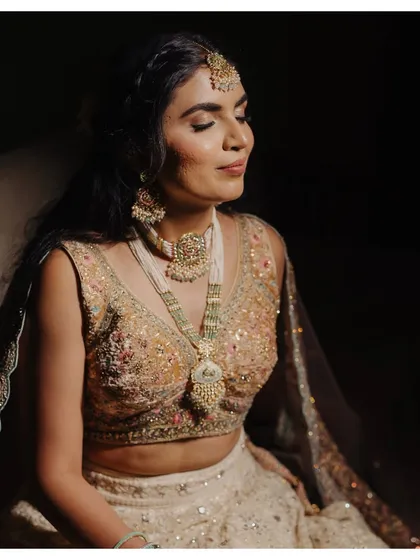 A serene portrait of Anthiya. The dramatic lighting highlights the glitter on her eyelids and the flawless finish of her skin.