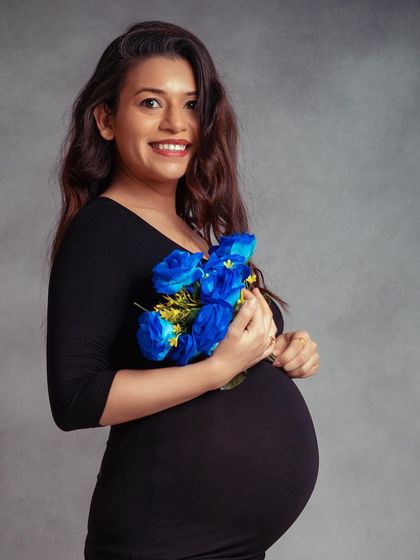 A bright and joyful portrait of a mom-to-be. The pop of color from the blue flowers adds a lovely touch to this classic shot.