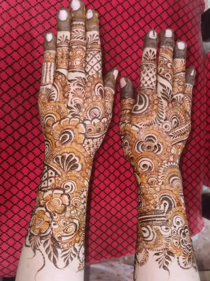 The back of the hands for the Indo-Arabic design, showing how the patterns create a cohesive look. The finger details are kept intricate to complement the bolder arm work.