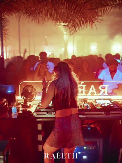 A view from the side of the DJ booth at Raeeth, showing the packed club and smoky atmosphere.