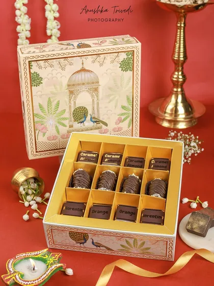 A beautifully designed chocolate box with traditional Indian motifs. The styling with a diya and jasmine flowers makes it a perfect gift for Diwali or a wedding.