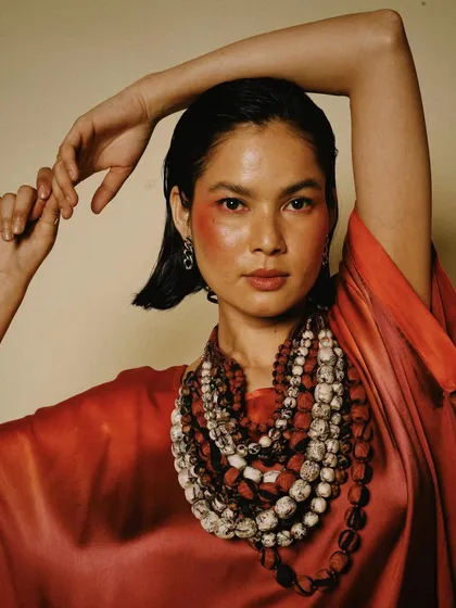 A powerful portrait for House of Wandering Silk, with the model adorned in beautiful, handcrafted jewelry that complements the rich red tones of her outfit.