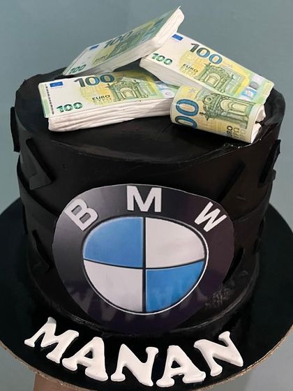 A bold statement cake for a BMW enthusiast, this design features the iconic logo and is topped with edible stacks of Euro notes. It's a fun and luxurious theme for a milestone birthday.