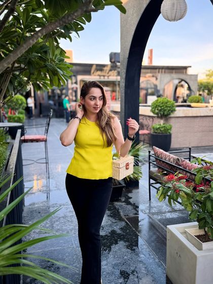 A breezy rooftop look with a bright yellow top and black pants. This is a great outfit for a summer evening out while traveling.