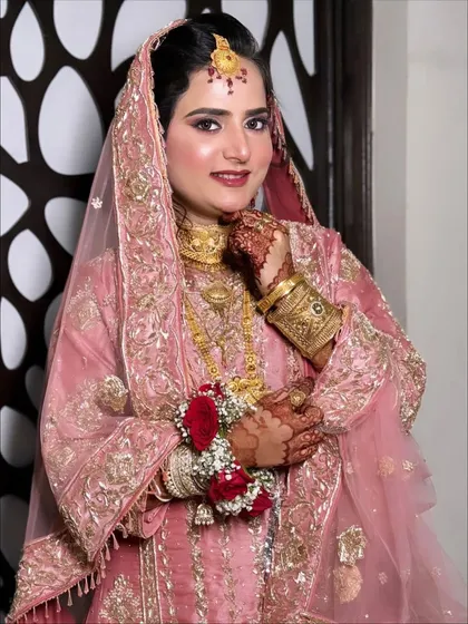 A confident and happy portrait, with the client looking directly at the camera, showcasing her radiant smile and flawless makeup.