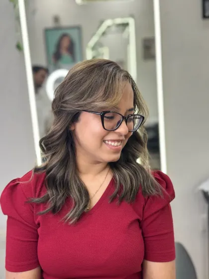 The client is all smiles with her new smoke blonde highlights. This look is effortlessly chic, with the cool tones framing her face and brightening her overall style.