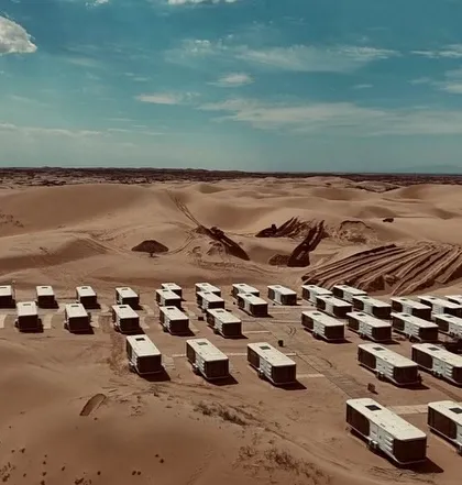 An aerial shot of our Space Capsule E8 units being deployed in a desert landscape. This showcases the scale and ambition of our modular hospitality projects.