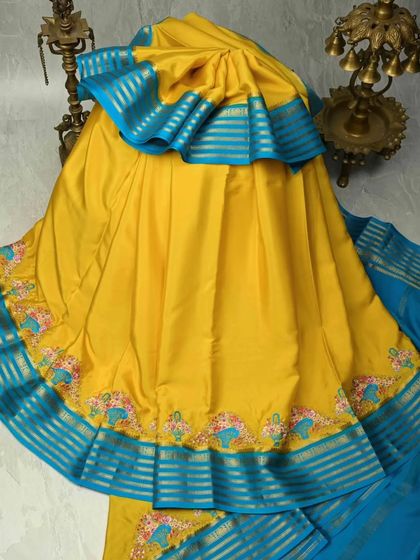 A vibrant yellow pure silk saree with a contrasting blue border. The border features charming elephant motifs, adding a touch of playful tradition to this beautiful piece.