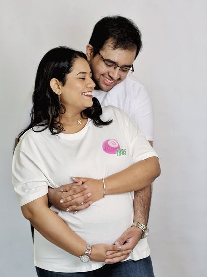 Even in casual outfits, the love shines through. This candid shot captures genuine laughter and joy between the couple during a relaxed, minimalist studio session.