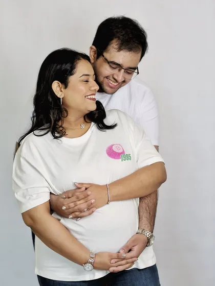 Even in casual outfits, the love shines through. This candid shot captures genuine laughter and joy between the couple during a relaxed, minimalist studio session.
