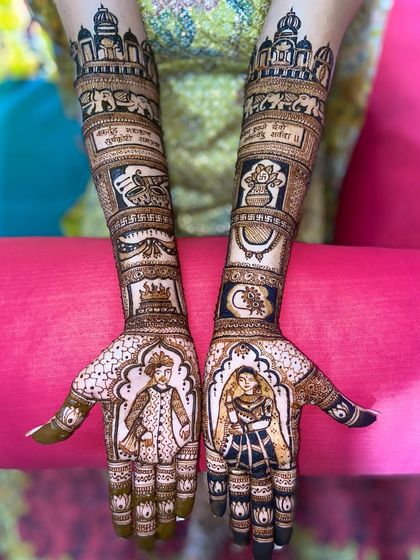 This grand bridal design features royal portraits on the palms. The arms are filled with story elements like a wedding procession, a crescent moon, and a sacred fire.