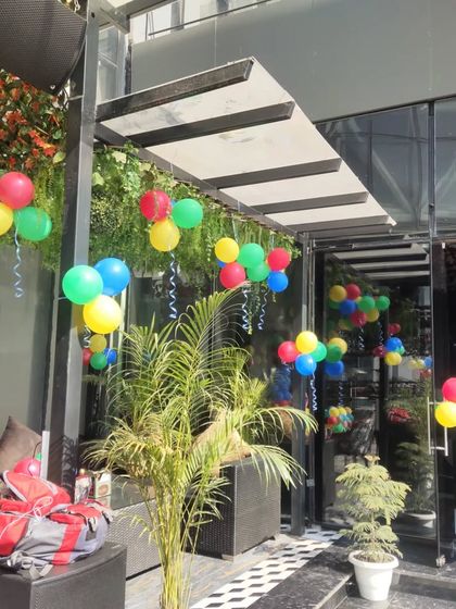 For this cafe's outdoor seating area, I hung simple multi-colored balloon bunches with ribbons to create a cheerful and casual party atmosphere.