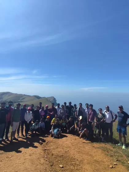 Another group photo on a clear day, showing the vastness of the sky and the mountains.