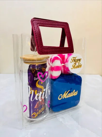 Another angle of the Rakhi hamper for a sister, showing the personalized name 'Maitri' on both the glass tumbler and the blue jewelry box.