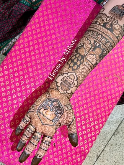 A full-arm bridal piece with a swan, kalash, and peacock, combining multiple auspicious elements.