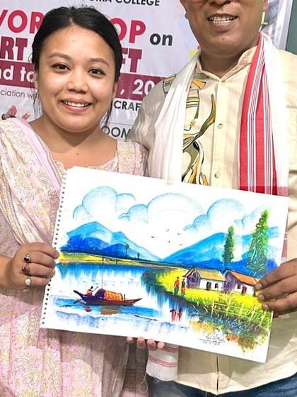 The first day of my Art and Craft workshop at Doomdooma College, presenting a completed landscape painting to a participant.