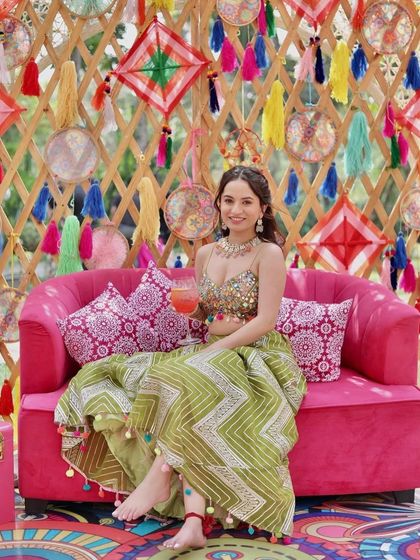 The bride relaxing on a pink sofa against a colourful backdrop, looking absolutely stunning.