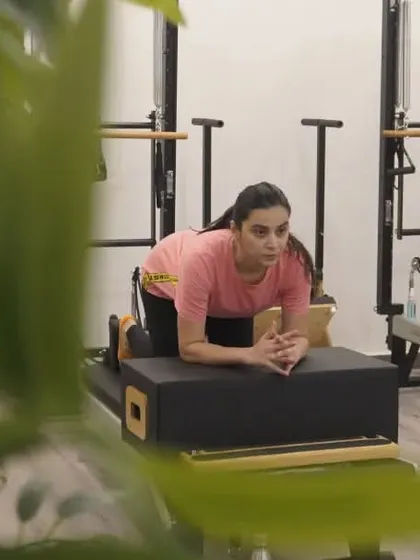 "Stretch with Strength and Control." This client, in a prone position on the reformer box, demonstrates the focus and mind-body connection that Pilates requires.