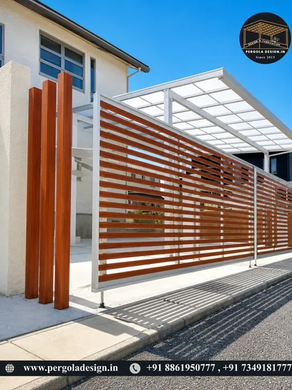 This design features a silver aluminium frame with a polycarbonate roof, complemented by decorative wooden pillars and a horizontal slat fence. It shows how we can mix materials to create a custom carport that is both modern and warm.