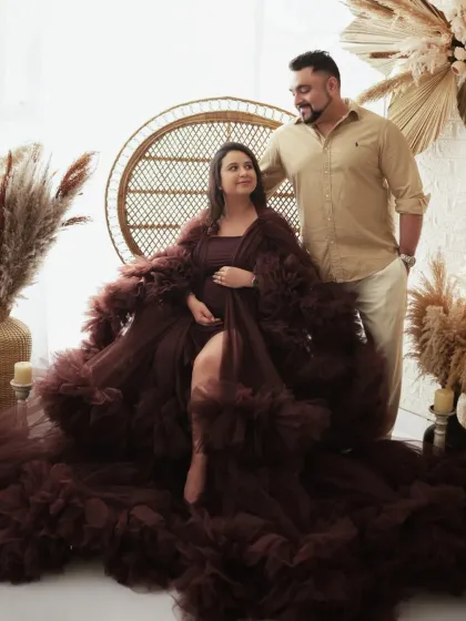 A classic seated portrait for an expecting couple. The mother-to-be looks serene and beautiful in a flowing gown, creating a timeless memory in my Gurgaon studio.