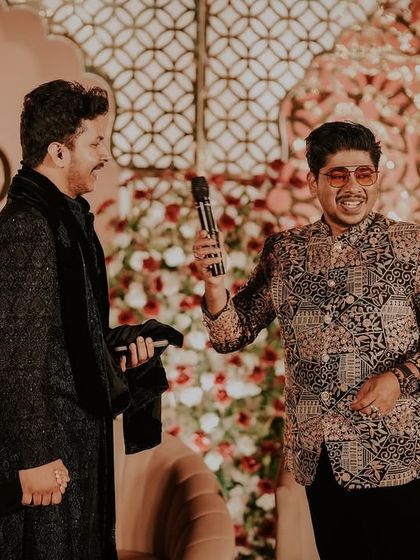 Interacting with a young guest and his father on stage during a reception. I ensure that my events are family-friendly and engaging for all age groups.