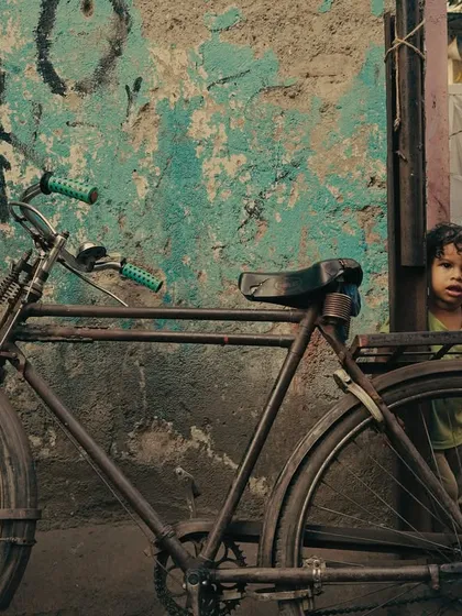 Street photography is about noticing the small stories. A child's curious glance from behind a bicycle against a textured wall is a raw, authentic moment that speaks volumes. It’s this kind of unscripted magic I aim to capture.