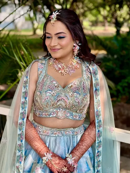 A portrait of the bride looking radiant and happy in her pastel Haldi look. The floral jewelry adds a beautiful, fresh touch.