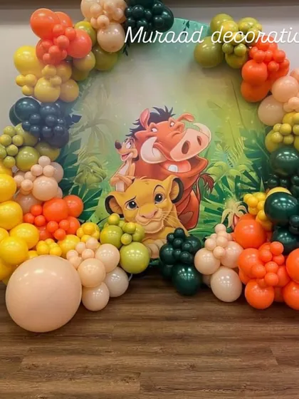 This circular backdrop features Simba, Timon, and Pumbaa, framed by a colorful organic balloon garland. It’s a fantastic focal point for a jungle or Hakuna Matata themed birthday party.