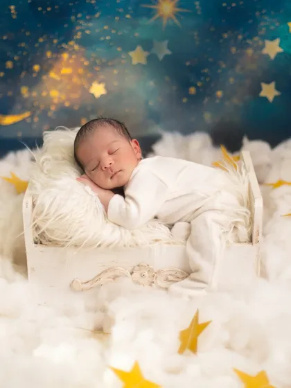 Asleep on a cloud under a starry night sky. I love using creative backdrops and props to transport your baby into a magical dream world for their first portraits.