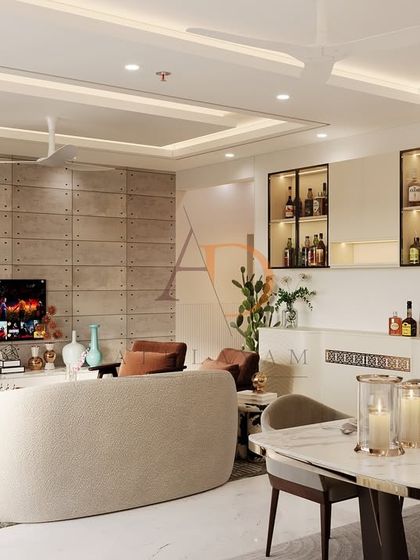 An open-plan living and dining space featuring a bold, industrial-luxe concrete panel wall for the TV and a built-in bar with fluted details.