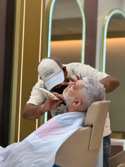 A perfect beard is all about the details. Here, our expert stylist is performing a precision beard shave, carefully defining the lines for a sharp and immaculate finish.