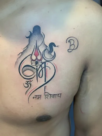 A beautiful chest tattoo combining the form of Shiva, the Om symbol, and the "Om Namah Shivay" mantra. The use of red and black ink creates a striking contrast.