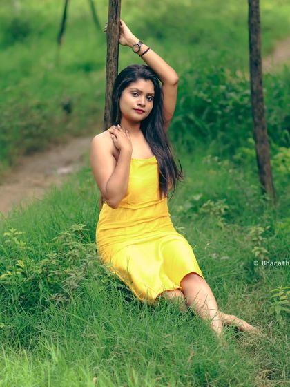 A relaxed, reclining pose in the grass. This is a great example of a casual and comfortable outdoor lifestyle portrait.