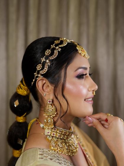 The side profile shows how the matha patti and statement earrings frame the face. This rental set is a favorite among brides for its classic elegance.
