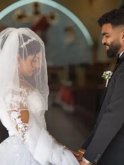 A beautiful moment between the bride and groom at the church entrance. The bride's veil adds a layer of softness and intimacy to this classic Catholic wedding photograph.