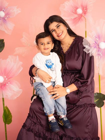 A lovely portrait of a mother and her young son against a floral studio backdrop. This image captures the sweet connection and love between them during a maternity session.