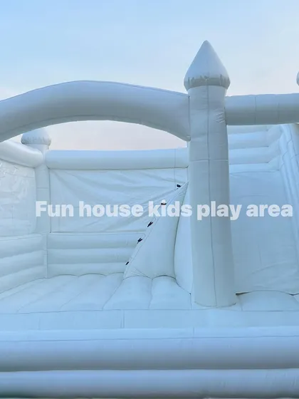 A clean, crisp shot of the interior of our white bounce castle, highlighting the climbing wall and slide features.