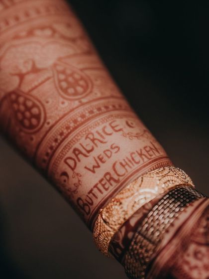 A close-up of the "Dalrice weds Butterchicken" hashtag after the henna stain has fully developed. It's a beautiful and lasting reminder of their unique story.