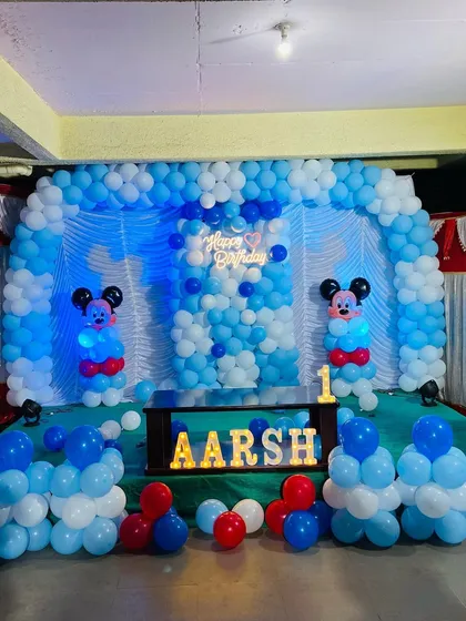The full stage view of the blue and white Mickey Mouse birthday party, showcasing the complete balloon backdrop.