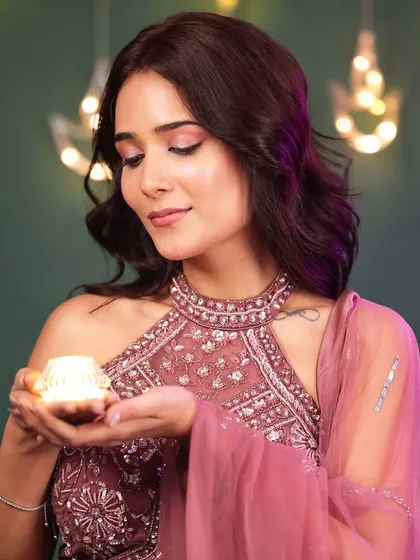 A serene portrait of a model in a pink ethnic outfit, holding a diya with a gentle expression, perfectly capturing the peaceful essence of Diwali.