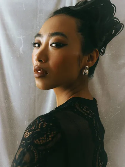 A classic beauty portrait with an elegant updo. The soft lighting and the model's over-the-shoulder gaze create a timeless and sophisticated feel.